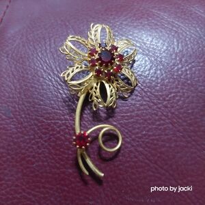 Gold tone flower brooch/pin with dark red rhinestones
